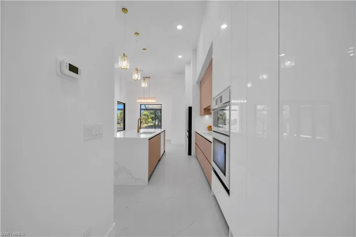 Contemporary kitchen featuring white high-gloss cabinetry and integrated appliances