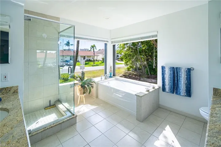Full bath with vanity, a bath, a shower stall, and light tile patterned flooring