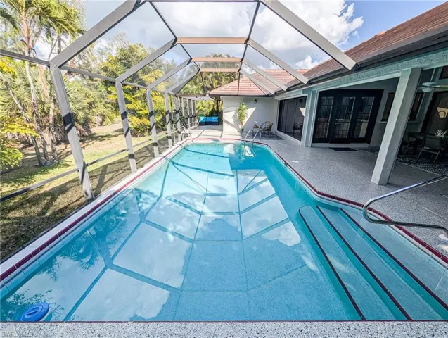 Swimming pool with a patio, a sunroom, a lanai, and a lawn