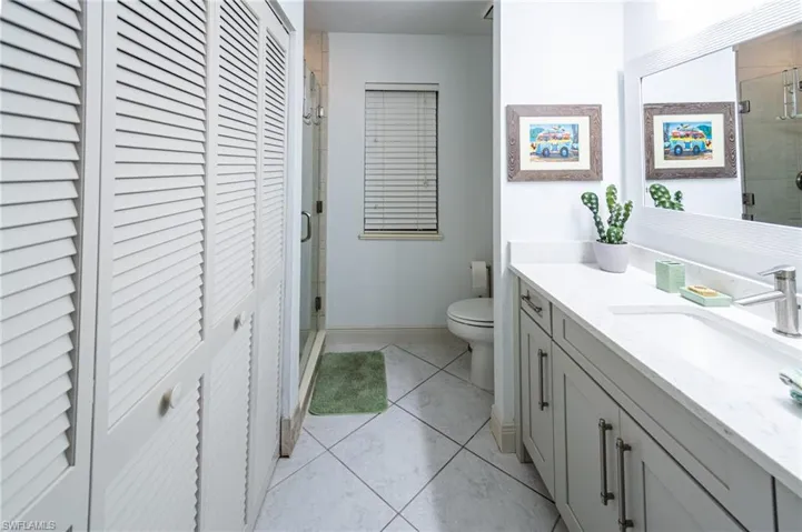 Full bathroom with a closet, vanity, and a shower stall