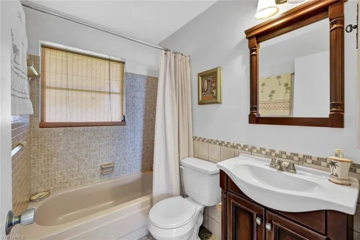 Guest bathroom with shower / tub combo, vanity + toilet