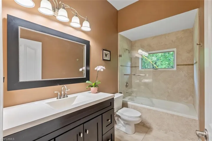 Full guest bath featuring vanity, tiled shower / bath, and light tile patterned floors