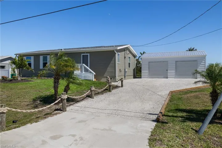 View of front of house featuring an outbuilding, a front yard, and a garage