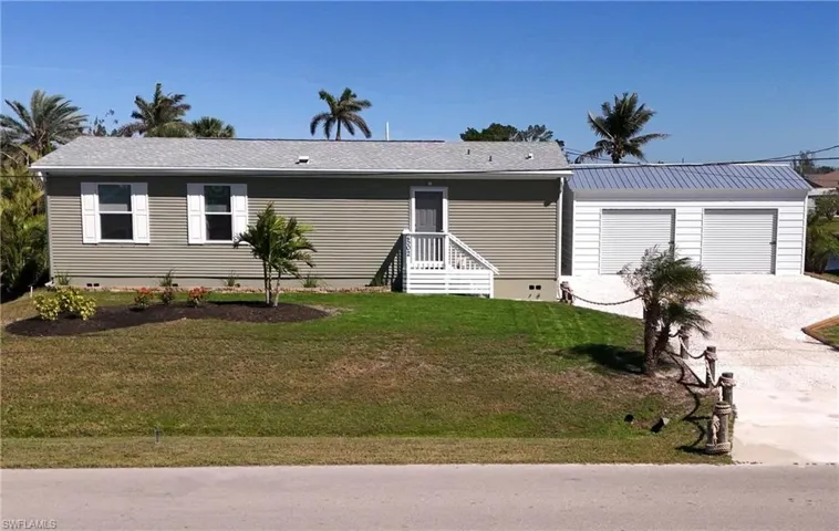 View of front facade with a front yard, crawl space, and driveway