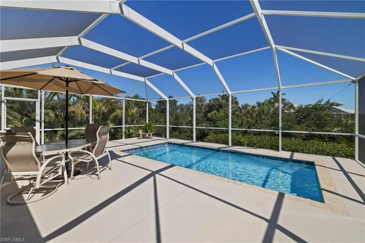 Pool featuring glass enclosure and a patio area