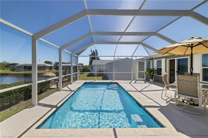 Pool with a lanai, a patio area, and a water view