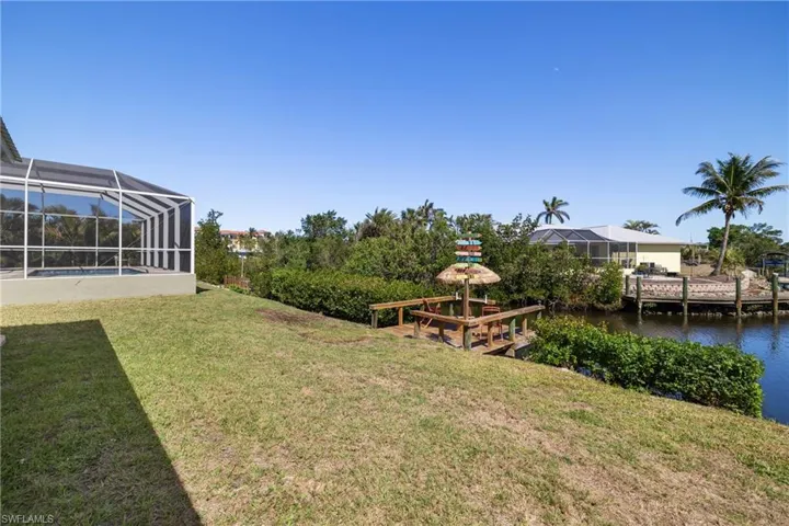 View of yard featuring glass enclosure and a water view