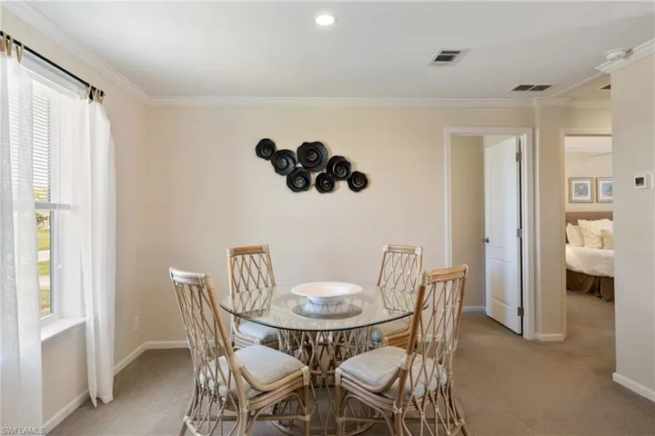 Carpeted dining room with visible vents, plenty of natural light, and baseboards