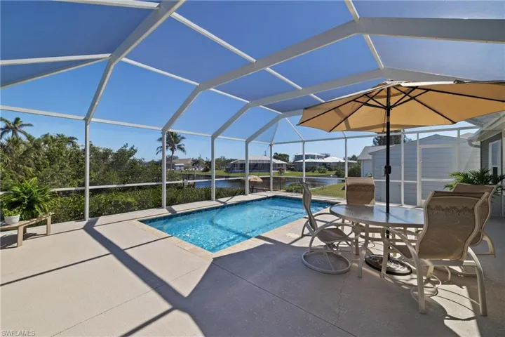 Pool with a patio area and glass enclosure
