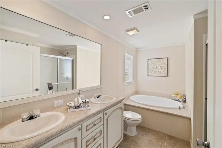 Bathroom featuring visible vents, a sink, a shower stall, and toilet