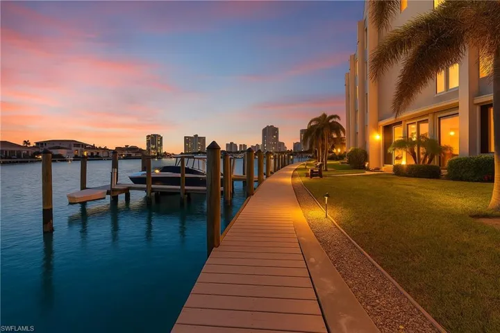 Dock area with a yard, a water view, and a city view