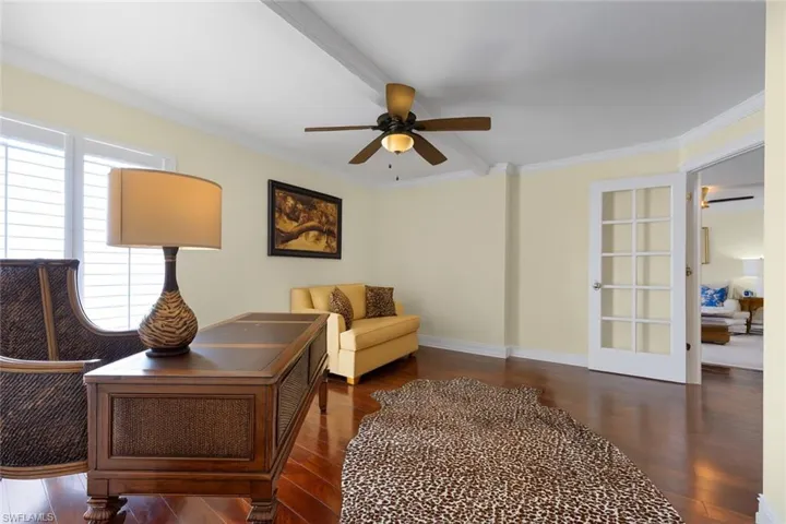 Office area featuring crown molding, ceiling fan, and dark wood finished floors