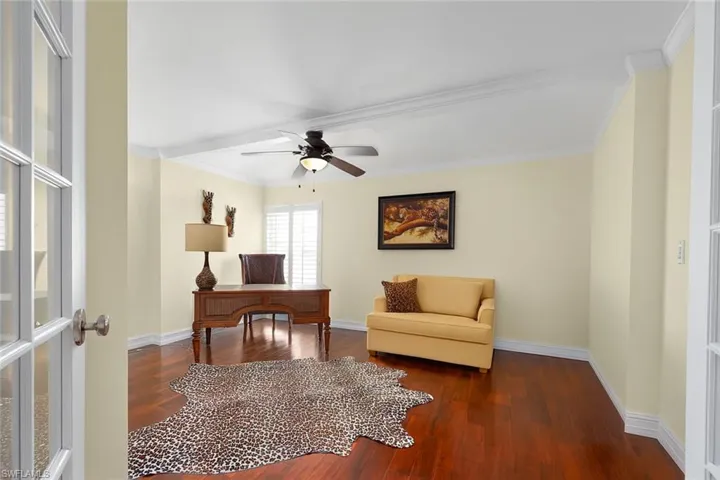 Home office with dark wood-style flooring, ornamental molding, a ceiling fan, and french doors