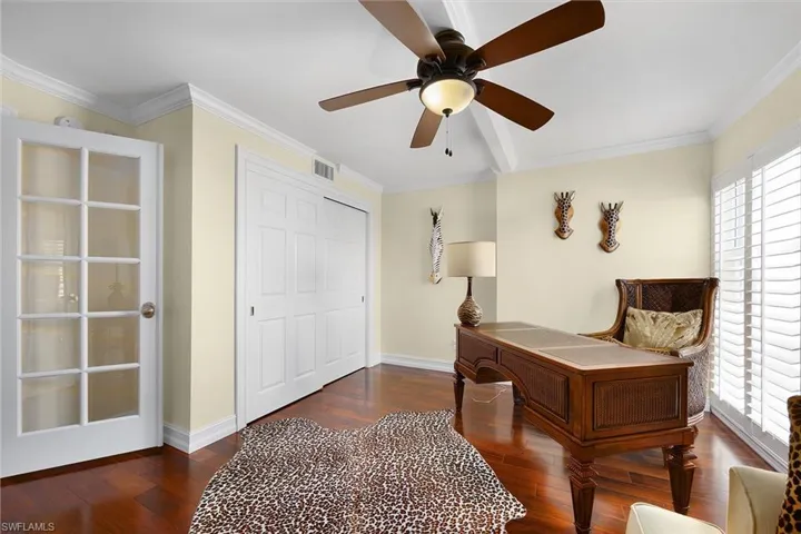 Sitting room featuring crown molding, dark wood-type flooring, and a ceiling fan