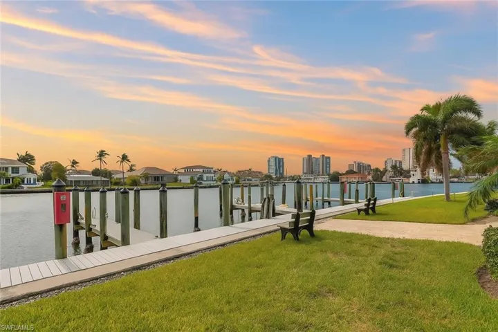 Dock area with a water view, a lawn, and boat lift