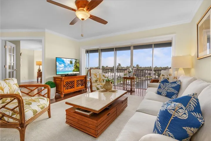 Living area with crown molding, wood finished floors, and ceiling fan
