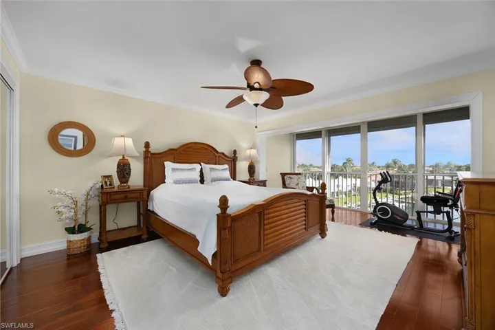 Bedroom featuring access to exterior, ornamental molding, dark wood-type flooring, and ceiling fan