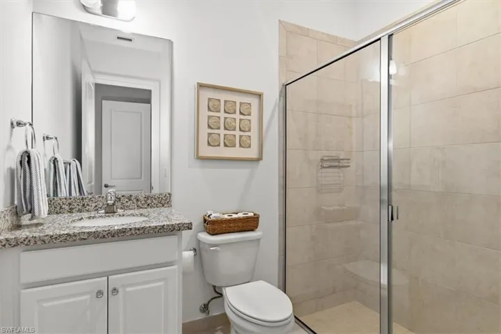 Full bath featuring a stall shower and vanity