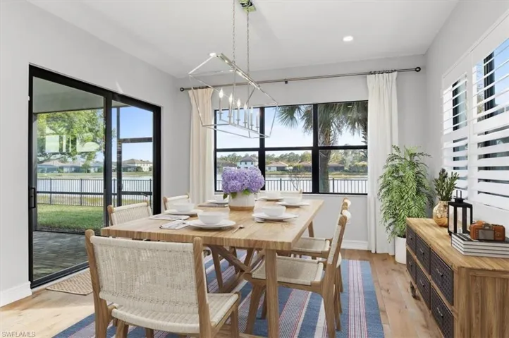 Virtual staged Dining area with light wood-style flooring and suspended lighting
