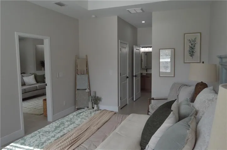 Bedroom featuring light hardwood / wood-style flooring and ensuite bathroom
