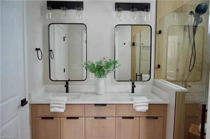 Bathroom featuring vanity and a shower with door