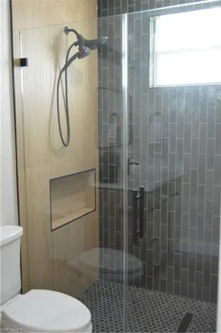 Bathroom with a shower with door and toilet