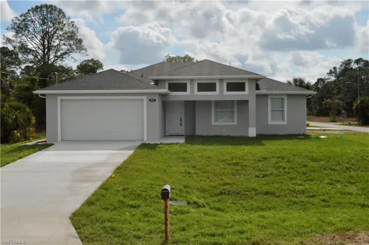 View of front of property with a front lawn and a garage