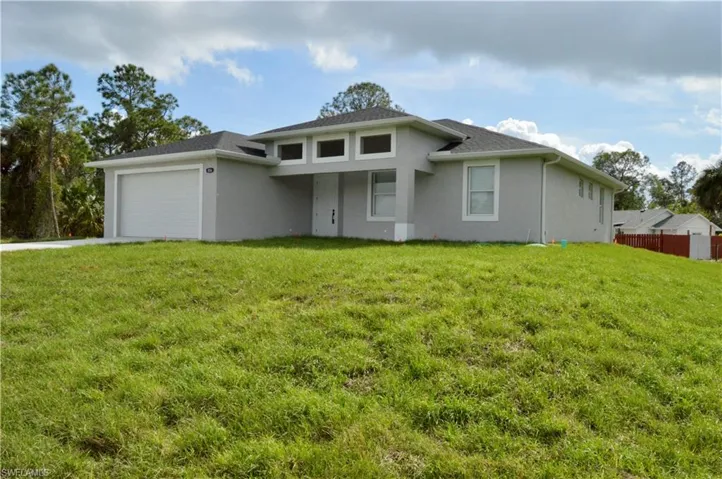 View of front of property featuring a garage and a front yard