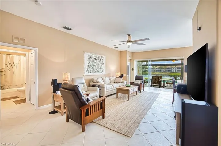 Living room with ceiling fan and light tile patterned floors