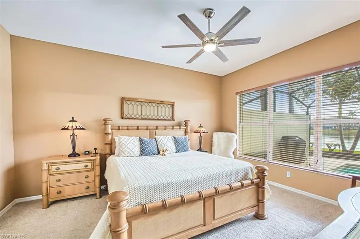 Bedroom with light carpet and a ceiling fan