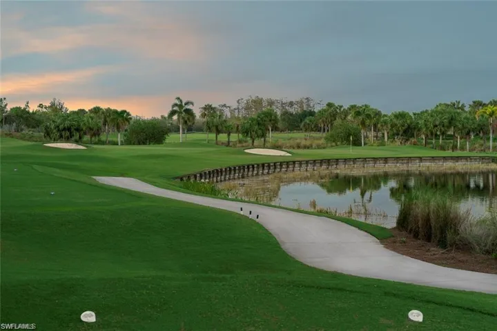 View of home's community with view of golf course, a water view, and view of wooded area