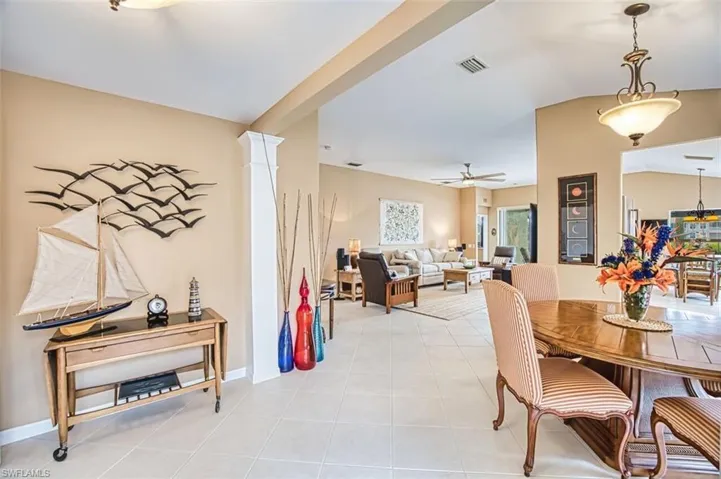 Dining space with lofted ceiling, light tile patterned flooring, and a ceiling fan