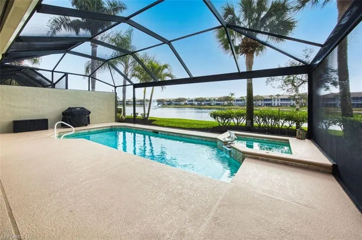 Integrated pool / spa with a sunroom, a water view, a patio, and grilling area