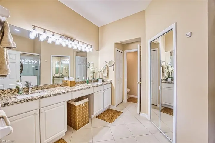 Bathroom featuring double vanity and light tile patterned flooring