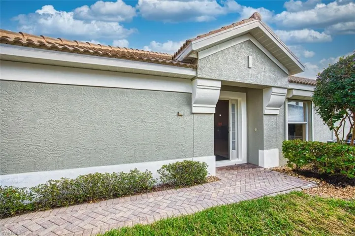 View of front of property with stucco siding and a tile roof