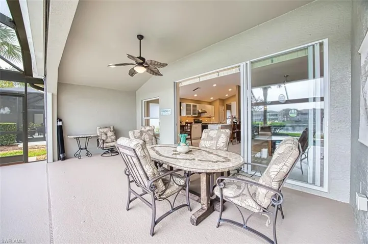 Sunroom with ceiling fan, outdoor dining area, lofted ceiling, and a patio