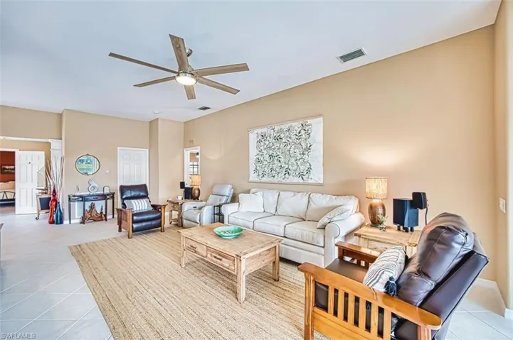Living area featuring ceiling fan and light tile patterned floors