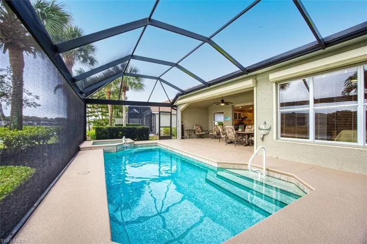 Relaxing pool / spa featuring a patio, a sunroom, a lanai, and outdoor dining space