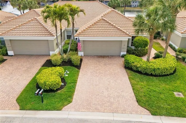 View of front of house with stucco siding, an attached garage, a tiled roof, and decorative driveway