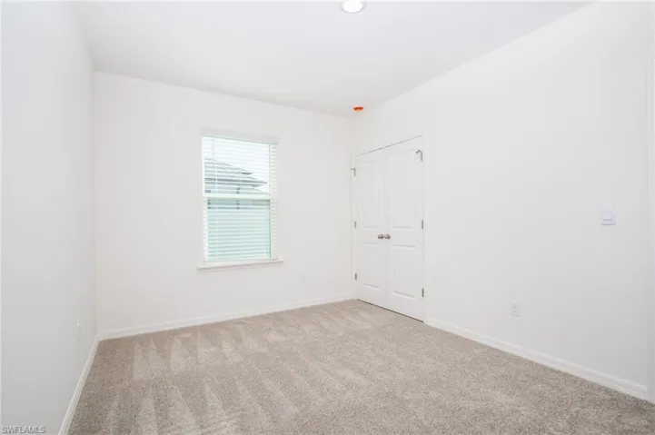 Empty room with baseboards and carpet