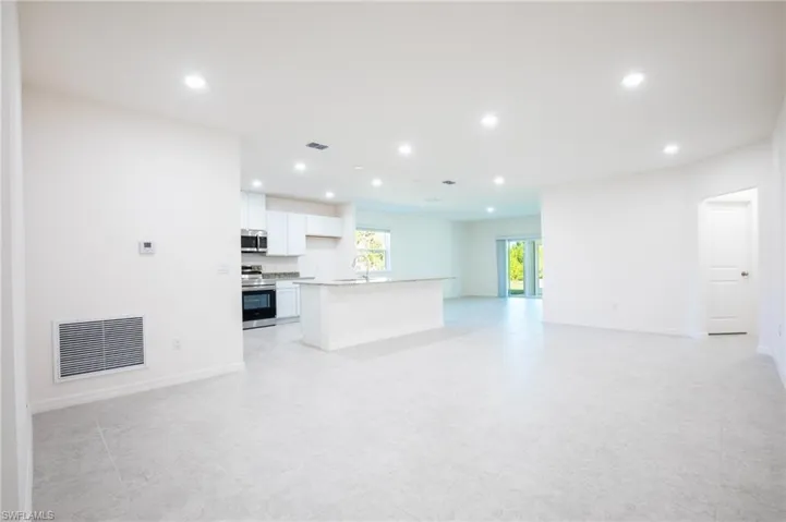Unfurnished living room with recessed lighting and baseboards