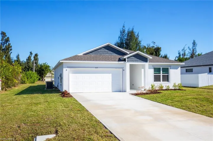 Ranch-style home with roof with shingles, a front yard, a garage, driveway, and stucco siding