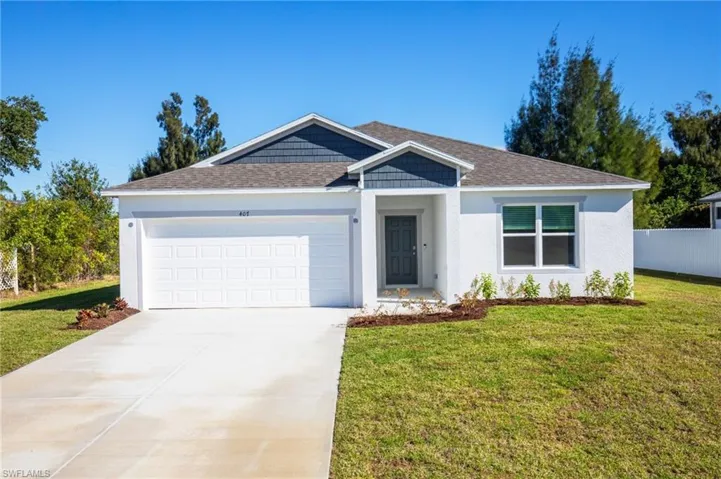 Single story home with a front yard, stucco siding, a garage, and concrete driveway