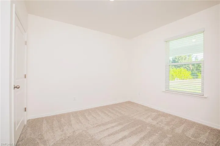 Carpeted empty room featuring baseboards