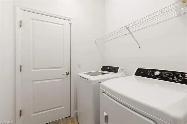 Laundry area featuring separate washer and dryer and light wood-style floors