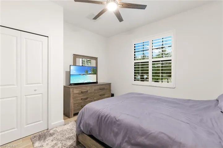 Bedroom with a closet, a ceiling fan, and light wood-style flooring