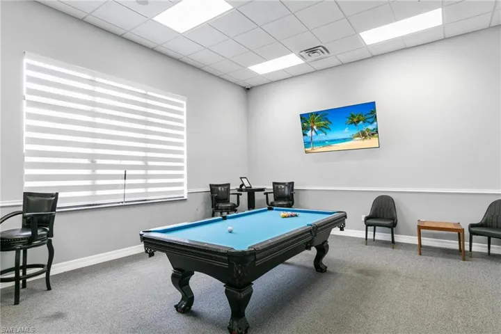 Rec room featuring billiards table, a paneled ceiling, and carpet flooring