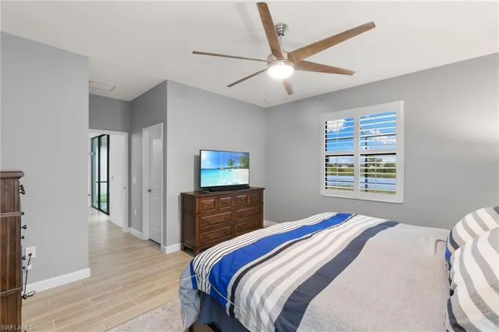 Bedroom with wood tiled floors and a ceiling fan