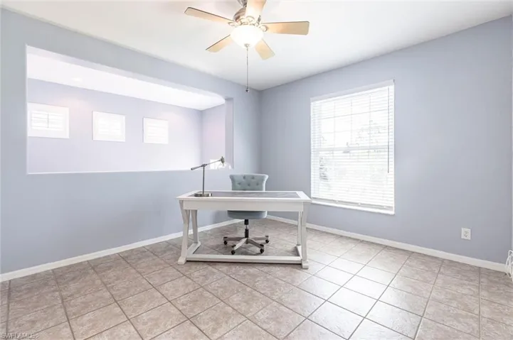 Office area with light tile patterned flooring and ceiling fan