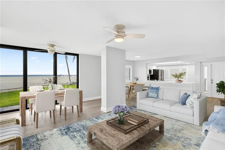 Living room with plank tile floors, a water view, expansive windows, and a ceiling fan